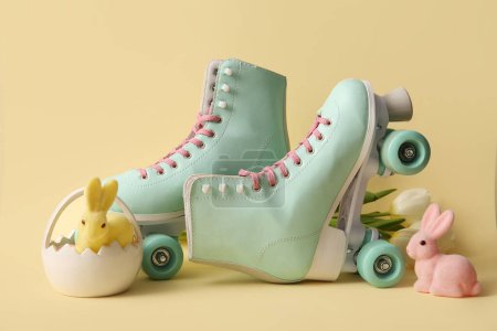 Vintage roller skates with toys bunny and beautiful tulips on yellow background. Easter celebration