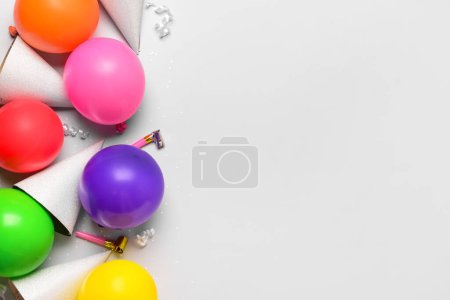 Téléchargez les photos : Composition avec chapeaux de fête, ballons et bruyants sur fond blanc - en image libre de droit
