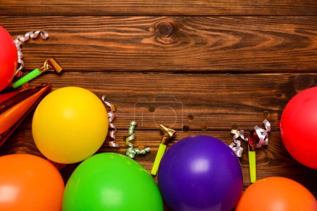 Téléchargez les photos : Ballons, bruyants et confettis sur fond de bois - en image libre de droit