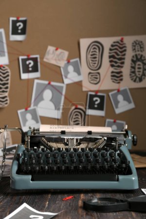 Retro-Schreibmaschine und Lupe auf Holztisch gegen Krimiwand