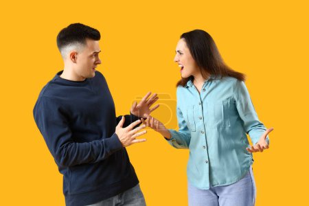 Photo for Young couple quarreling on yellow background - Royalty Free Image