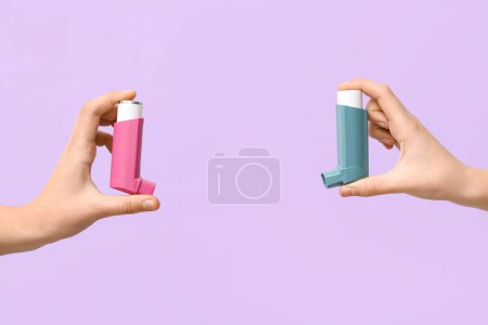 Téléchargez les photos : Mains de l'enfant avec inhalateurs d'asthme sur fond lilas - en image libre de droit