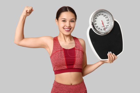 Photo for Young woman in sportswear and with weight scales on light background. Slimming concept - Royalty Free Image
