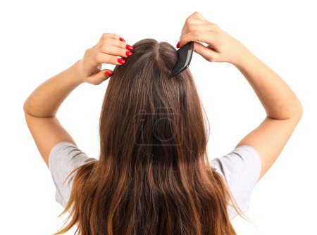 Mujer joven con caspa peinando el pelo sobre fondo blanco, vista posterior