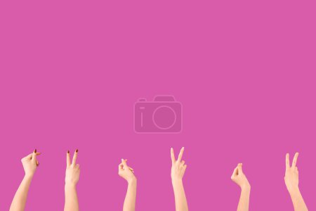 Téléchargez les photos : Mains féminines montrant des gestes de paix et tenant quelque chose sur fond violet - en image libre de droit