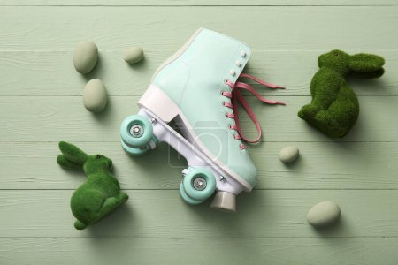 Vintage roller skate with Easter eggs and toys bunny on green wooden background
