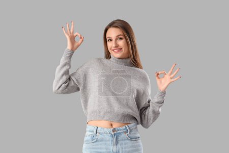 Foto de Mujer joven mostrando OK sobre fondo claro - Imagen libre de derechos