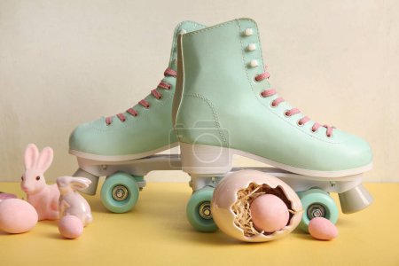 Vintage roller skates with Easter eggs and toys bunny on yellow table