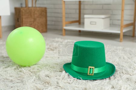 Leprechaun's hat and green balloon on floor in living room. St. Patrick's Day celebration