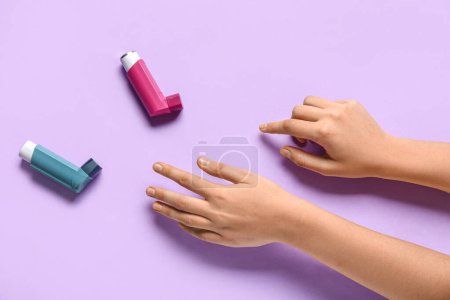 Téléchargez les photos : Mains de l'enfant avec inhalateurs d'asthme sur fond lilas - en image libre de droit