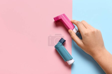 Téléchargez les photos : Main de l'enfant avec inhalateurs d'asthme sur fond de couleur - en image libre de droit