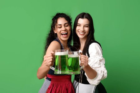 Photo for Irish waitresses with glasses of beer on green background. St. Patrick's Day celebration - Royalty Free Image
