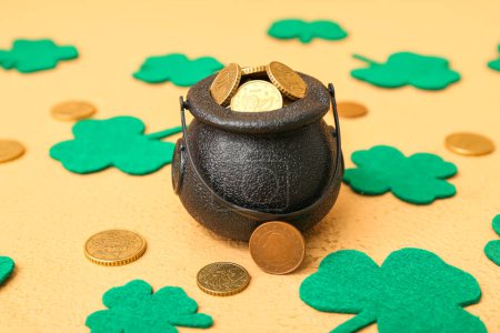 Photo for Leprechaun pot with golden coins and clover leaves on beige background. St. Patrick's Day celebration - Royalty Free Image