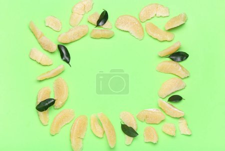 Foto de Marco hecho de piezas de fruta de pomelo y hojas sobre fondo verde - Imagen libre de derechos
