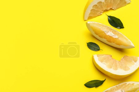 Foto de Pomelo rodajas de frutas y hojas sobre fondo amarillo - Imagen libre de derechos