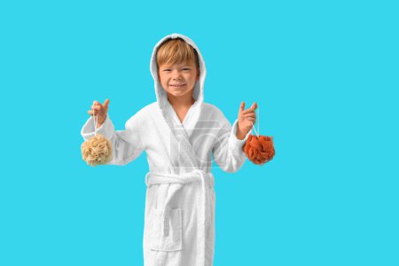 Photo for Cute little boy in bathrobe with loofahs on blue background - Royalty Free Image