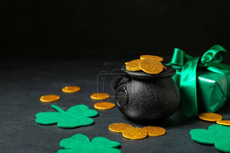 Photo for Leprechaun pot with golden coins and gift box on table against dark background. St. Patrick's Day celebration - Royalty Free Image