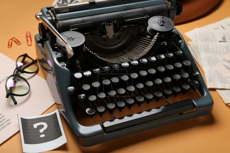 Máquina de escribir retro, anteojos y signo de interrogación sobre fondo de color