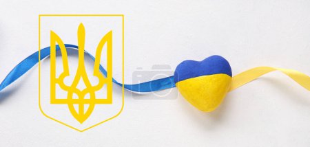 Heart and ribbon in colors of Ukrainian flag with coat of arms on light background