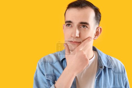 Téléchargez les photos : Jeune homme réfléchi sur fond jaune, gros plan - en image libre de droit