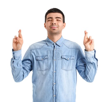 Photo for Young man crossing fingers on white background - Royalty Free Image