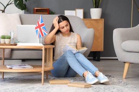 Müde junge Frau mit Buch lernt englische Sprache online zu Hause