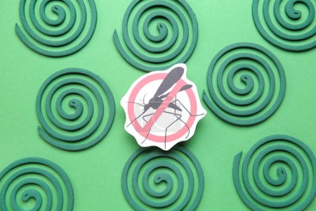 Mosquito spirals and anti insect sign on green background