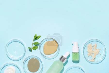 Photo for Petri dishes with samples, bottles of cosmetic products and plant leaves on blue background - Royalty Free Image