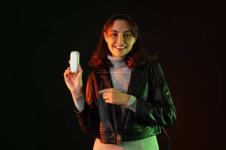 Téléchargez les photos : Jeune femme avec bloc de cigare électronique sur fond sombre - en image libre de droit