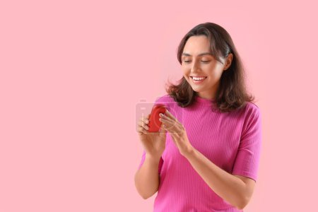 Téléchargez les photos : Jeune femme avec bloc de cigare électronique sur fond rose - en image libre de droit