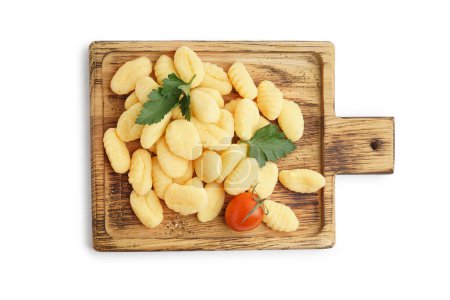 Board with tasty gnocchi, tomato and parsley on white background