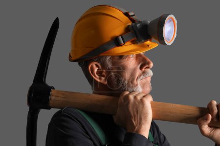 Photo for Mature miner man with pick axe on dark background, closeup - Royalty Free Image