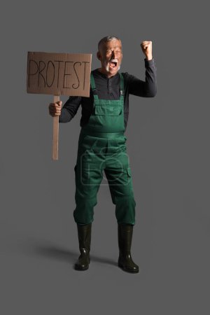 Protesting miner man with placard on dark background