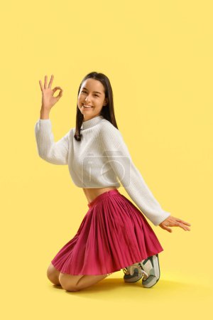 Foto de Mujer joven mostrando OK sobre fondo amarillo - Imagen libre de derechos