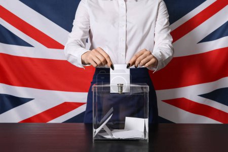 Votación de la mujer joven cerca de las urnas contra la bandera del Reino Unido, primer plano
