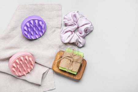 Hair scalp massagers with shampoo bar and scrunchy on grey background