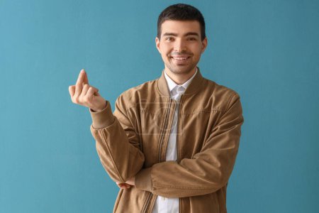Photo for Young man snapping fingers on blue background - Royalty Free Image