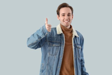 Photo for Young man showing thumb-up on light background - Royalty Free Image