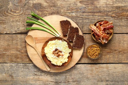Plate of tasty banosh, bread and bacon on wooden background