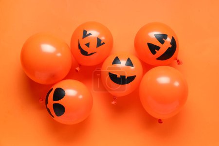 Funny Halloween orange balloons on color background