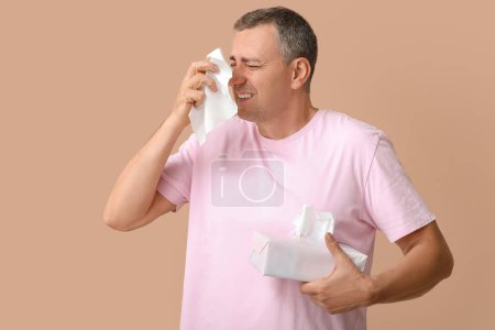Kranker reifer Mann mit Nasenbluten auf braunem Hintergrund