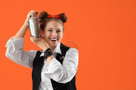 Female bartender with shaker on orange background