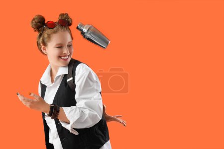 Female bartender throwing shaker on orange background