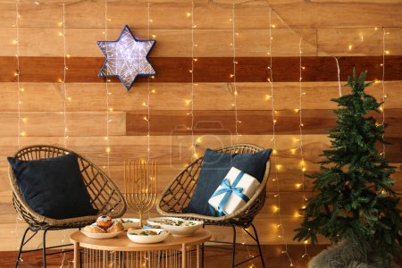 Téléchargez les photos : Intérieur du salon avec dîner festif, lumières incandescentes et décorations traditionnelles Hanoukka - en image libre de droit