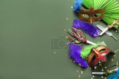 Carnival masks with party horns and feathers for Mardi Gras celebration on green background