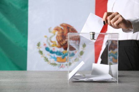 Voting young woman near ballot box against Mexican flag, closeup