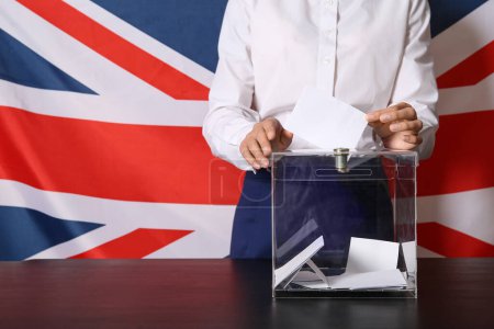 Voting young woman near ballot box against UK flag, closeup