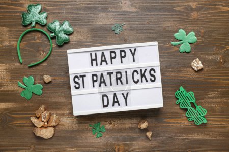 Photo for Board with words HAPPY ST PATRICKS DAY, plastic eyeglases and decor on wooden background - Royalty Free Image