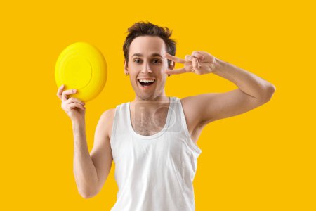 Photo for Happy young man with frisbee disk on yellow background - Royalty Free Image