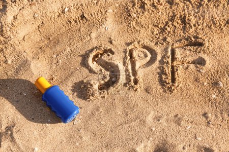 Composición creativa con botella de crema protector solar sobre arena en la playa de mar